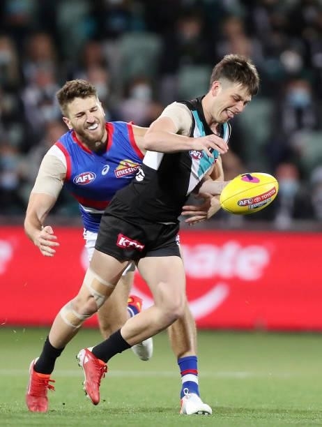 Zak Butters of the Power is tackled by Marcus Bontempelli of the Bulldogs during the 2021 AFL Second Preliminary Final match between the Port...