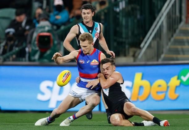 Adam Treloar of the Bulldogs is tackled by Karl Amon of the Power during the 2021 AFL Second Preliminary Final match between the Port Adelaide Power...