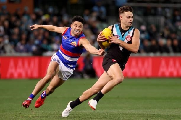 Jason Johannisen of the Bulldogs tackles Karl Amon of the Power during the 2021 AFL Second Preliminary Final match between the Port Adelaide Power...