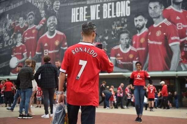 Manchester United fans wearing Cristiano Ronaldo shirts pose for photos outside the ground ahead of the English Premier League football match between...