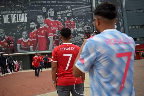 Manchester United fan wearing a Cristiano Ronaldo shirt takes a photo of another fan wearing a Cristiano Ronaldo shirt outside the ground ahead of...
