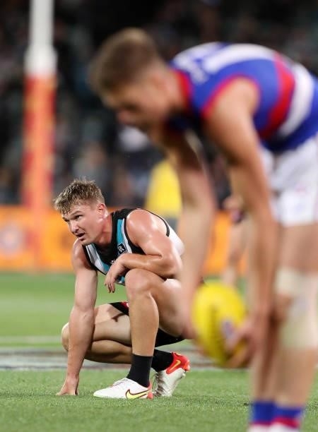 Ollie Wines of the Power slumps to the ground as the Bulldogs line up for another goal during the 2021 AFL Second Preliminary Final match between the...