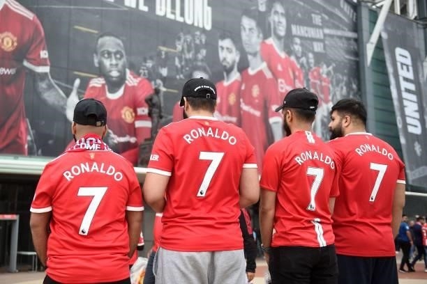 Manchester United fans wearing Cristiano Ronaldo shirts pose outside the ground ahead of the English Premier League football match between Manchester...