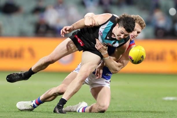 Darcy Byrne-Jones of the Power is tackled by Adam Treloar of the Bulldogs during the 2021 AFL Second Preliminary Final match between the Port...
