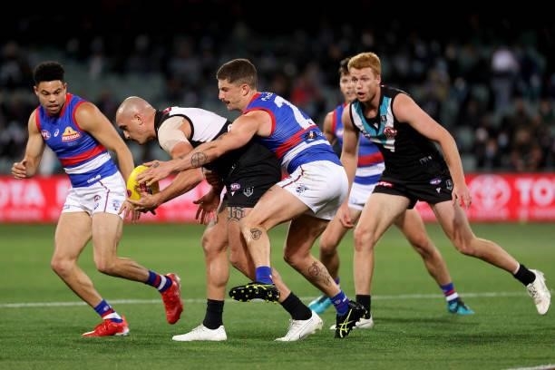 Sam Powell-Pepper of the Power is tackled by Tom Liberatore of the Bulldogs during the 2021 AFL Second Preliminary Final match between the Port...
