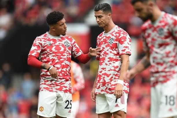 Manchester United's English striker Jadon Sancho speaks to Manchester United's Portuguese striker Cristiano Ronaldo as they warm up ahead of the...