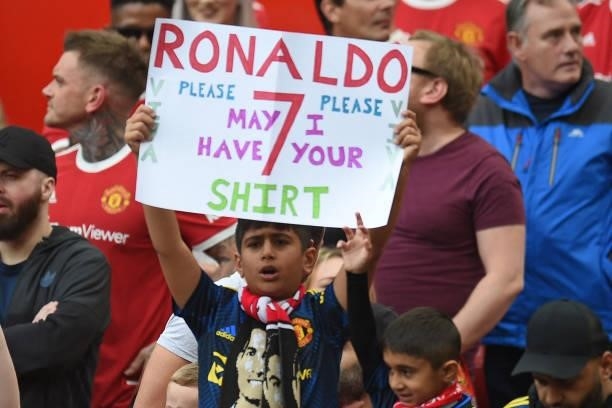 Young fan holds up a sign asking for Manchester United's Portuguese striker Cristiano Ronaldo's shirt ahead of the English Premier League football...