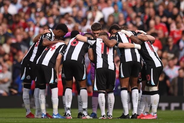 Newcastle players form a group huddle on the pitch ahead of the English Premier League football match between Manchester United and Newcastle at Old...