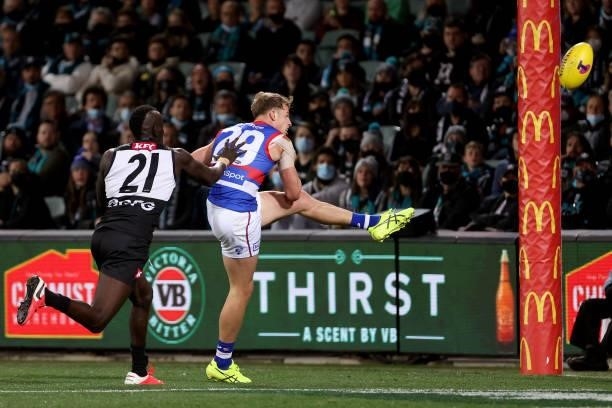 Mitch Hannan of the Bulldogs kicks a goal in front of Aliir Aliir of the Power during the 2021 AFL Second Preliminary Final match between the Port...