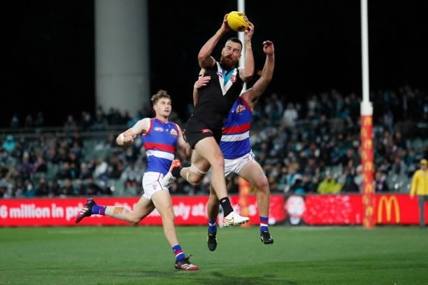 Charlie Dixon of the Power and Zaine Cordy of the Bulldogs compete for the ball during the 2021 AFL Second Preliminary Final match between the Port...