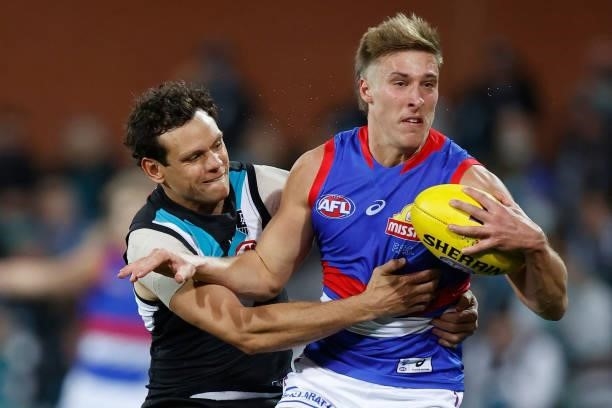 Roarke Smith of the Bulldogs is tackled by Steven Motlop of the Power during the 2021 AFL Second Preliminary Final match between the Port Adelaide...