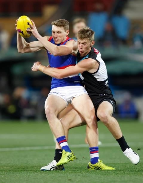 Bailey Dale of the Bulldogs is tackled by Todd Marshall of the Power during the 2021 AFL Second Preliminary Final match between the Port Adelaide...
