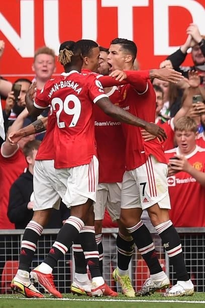 Manchester United's Portuguese striker Cristiano Ronaldo celebrates with teammates after scoring the opening goal of the English Premier League...