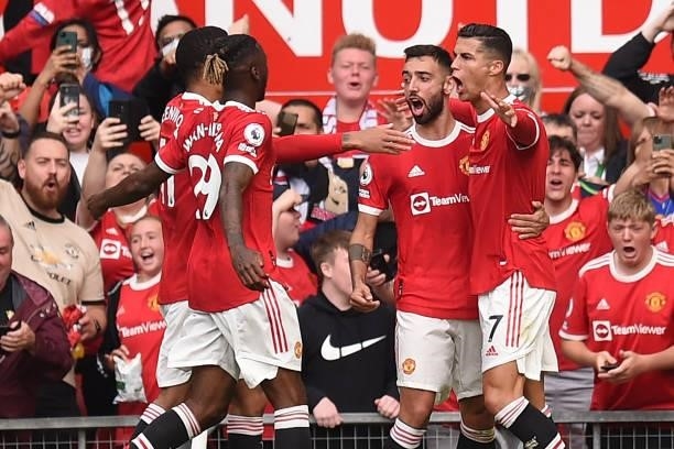 Manchester United's Portuguese striker Cristiano Ronaldo celebrates with teammates after scoring the opening goal of the English Premier League...