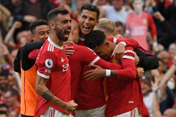 Manchester United's Portuguese striker Cristiano Ronaldo celebrates with teammates after scoring their second goal during the English Premier League...