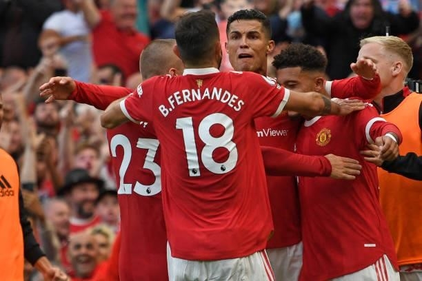 Manchester United's Portuguese striker Cristiano Ronaldo celebrates with teammates after scoring their second goal during the English Premier League...
