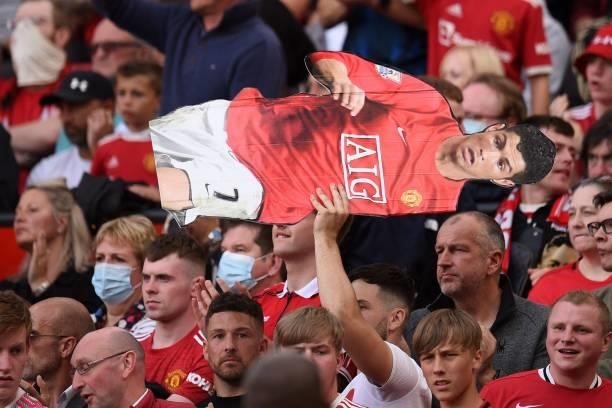 Supporter holds up a lifesized cut-out of Manchester United's Portuguese striker Cristiano Ronaldo during the English Premier League football match...