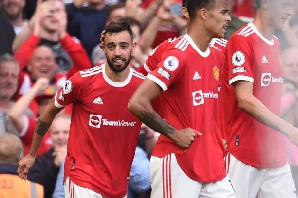 Manchester United's Portuguese midfielder Bruno Fernandes celebrates with teammates after scoring their third goal during the English Premier League...
