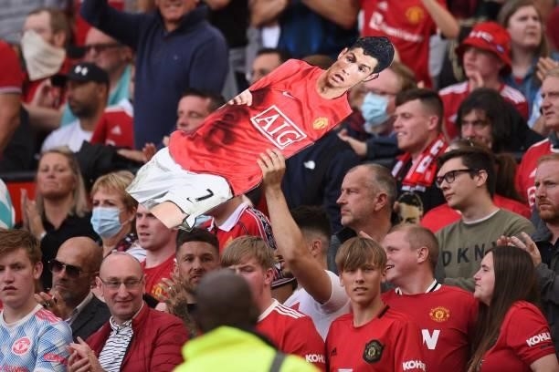 Supporter holds up a lifesized cut-out of Manchester United's Portuguese striker Cristiano Ronaldo during the English Premier League football match...