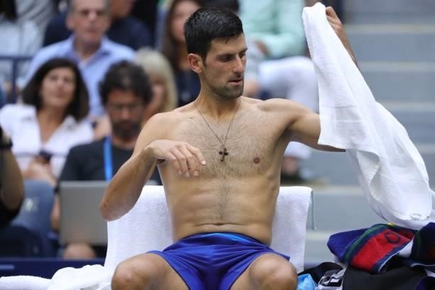 Novak Djokovic of Serbia changes his shirt during a break against Daniil Medvedev of Russia in the first set of the Men's Singles final match at the...