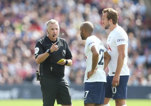 Referee Jonathan Moss shows Tottenham Hotspur's Lucas Moura a yellow card as Harry Kane looks on during the Premier League match between Crystal...