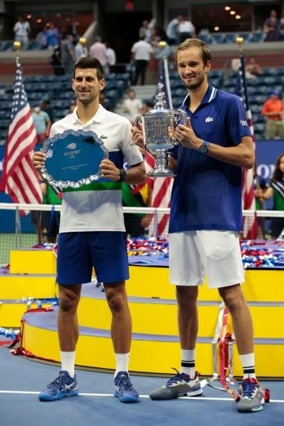 Winner Russia's Daniil Medvedev and Serbia's Novak Djokovic hold their trophies after the 2021 US Open Tennis tournament men's final match against at...