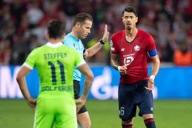 Referee Danny Makkelie and Jose Fonte of Lille OSC discusses during the UEFA Champions League group G match between Lille OSC and VfL Wolfsburg at...