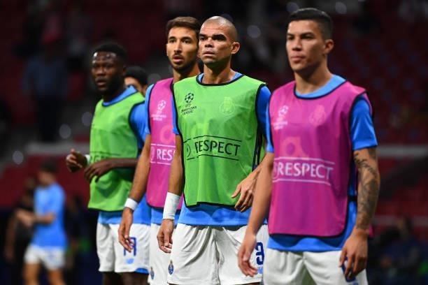 Porto's Portuguese defender Pepe warms up with teammates before the UEFA Champions League first round group B football match between Atletico Madrid...