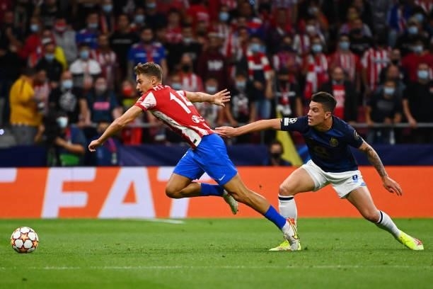 Atletico Madrid's Spanish midfielder Marcos Llorente is challenged by FC Porto's Colombian midfielder Mateus Uribe during the UEFA Champions League...