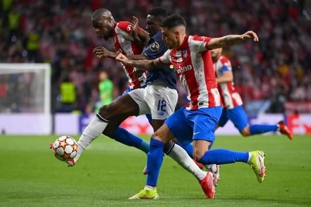 Porto's Nigerian defender Zaidu Sanusi is challenged by Atletico Madrid's French midfielder Geoffrey Kondogbia and Atletico Madrid's Uruguayan...