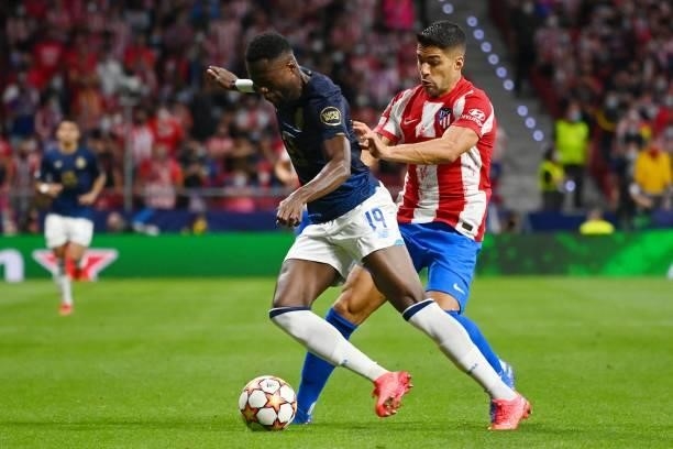 Porto's Congolese defender Chancel Mbemba is challenged by Atletico Madrid's Uruguayan forward Luis Suarez during the UEFA Champions League first...
