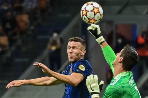 Real Madrid's Belgian goalkeeper Thibaut Courtois deflects a shot under pressure from Inter Milan's Croatian midfielder Ivan Perisic during the UEFA...