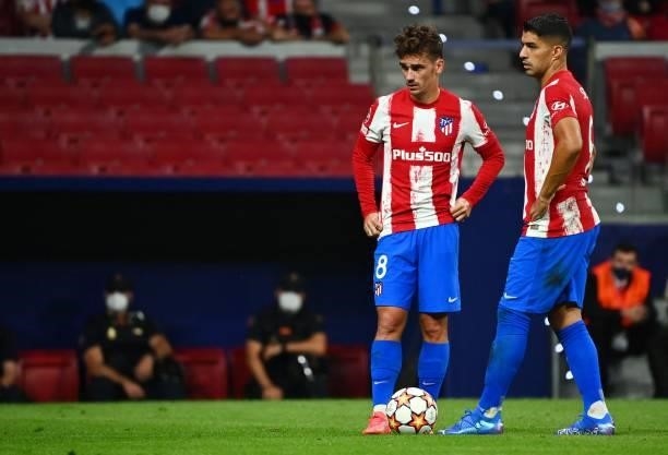 Atletico Madrid's Spanish midfielder Antoine Griezmann and Atletico Madrid's Uruguayan forward Luis Suarez stand on the pitch during the UEFA...
