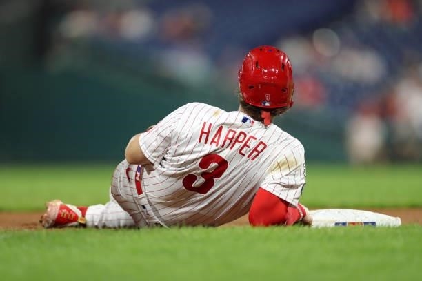Bryce Harper of the Philadelphia Phillies lays on the ground after stealing third base in the fifth inning during a game against the Chicago Cubs at...