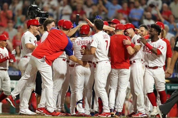 Jean Segura of the Philadelphia Phillies celebrates with teammates after Andrew Knapp scored the winning run on a passed ball in the ninth inning...