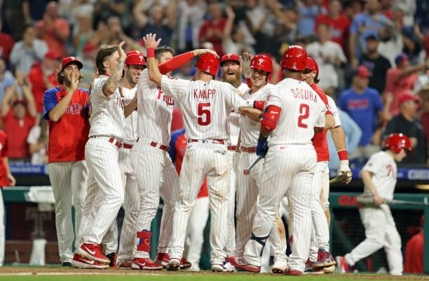 Andrew Knapp of the Philadelphia Phillies celebrates with teammates after scoring the winning run on a passed ball in the ninth inning during a game...