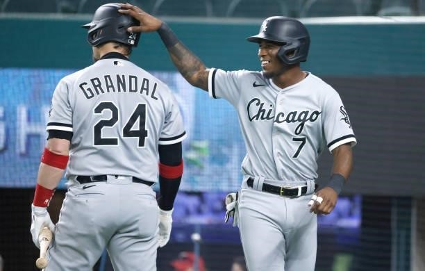 Tim Anderson of the Chicago White Sox celebrates with teammate Yasmani Grandal after scoring a run against the Texas Rangers during the first inning...