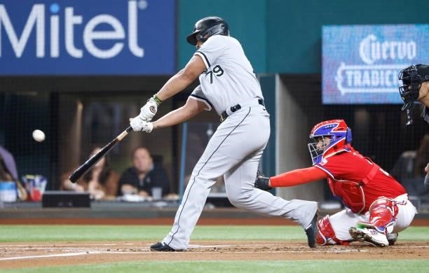 Jose Abreu of the Chicago White Sox hits a sacrifice fly to score a run against the Texas Rangers during the first inning at Globe Life Field on...