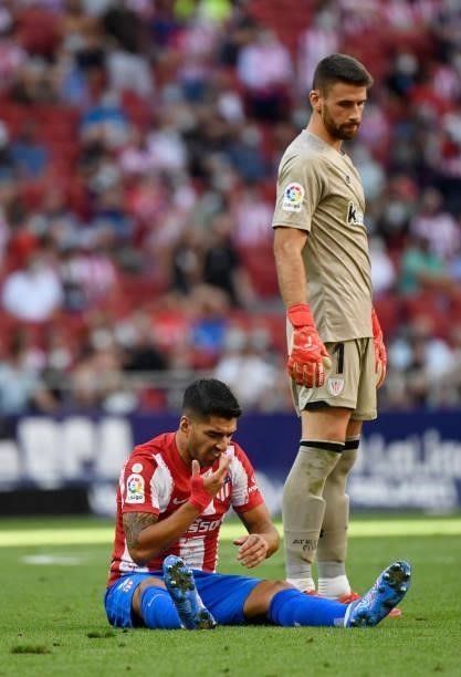 Atletico Madrid's Uruguayan forward Luis Suarez sits on the pitch next to Athletic Bilbao's Spanish goalkeeper Unai Simon during the Spanish League...