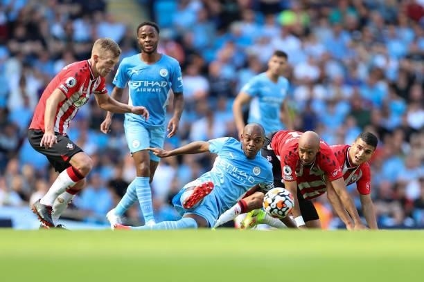 Nathan Redmond and Mohamed Elyounoussi of Southampton watch as Fernandinho of Man City passes the ball away during the Premier League match between...