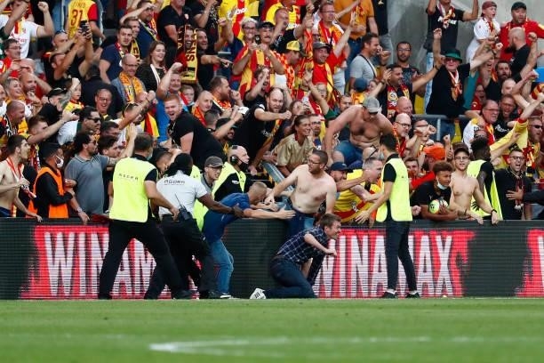 Fans of Lens try to go on the pitch during the Ligue 1 Uber Eats match between Lens and Lille at Stade Bollaert-Delelis on September 18, 2021 in...