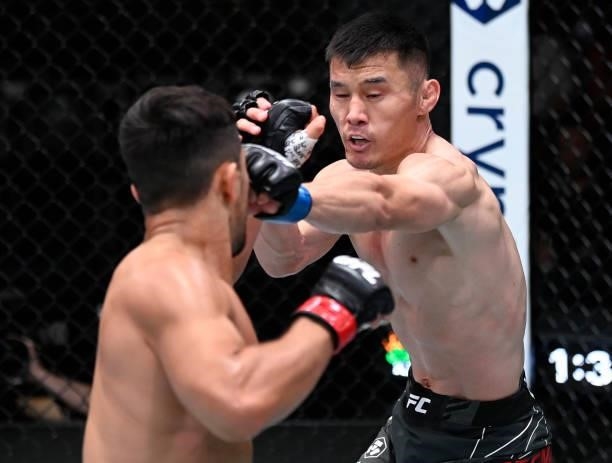 In this handout photo provided by UFC, Alatengheili of China punches Gustavo Lopez in a bantamweight fight during the UFC Fight Night event at UFC...