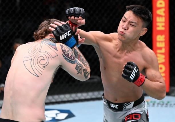 In this handout photo provided by UFC, Rong Zhu of Tibet punches Brandon Jenkins in a lightweight fight during the UFC Fight Night event at UFC APEX...