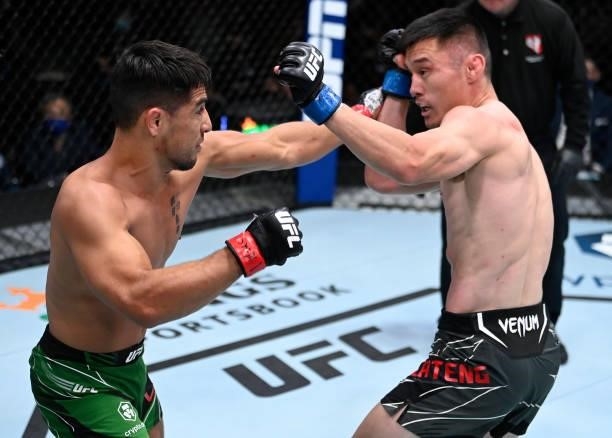In this handout photo provided by UFC, Gustavo Lopez punches Alatengheili of China in a bantamweight fight during the UFC Fight Night event at UFC...