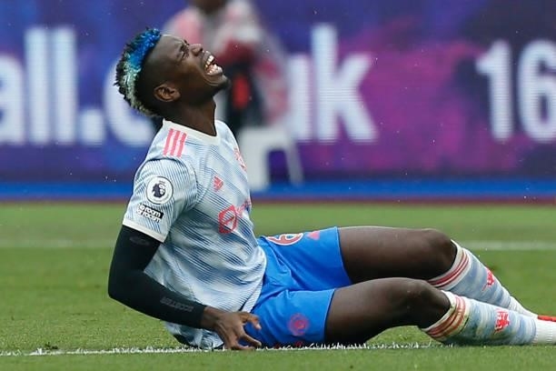 Manchester United's French midfielder Paul Pogba reacts after picking up an injury during the English Premier League football match between West Ham...