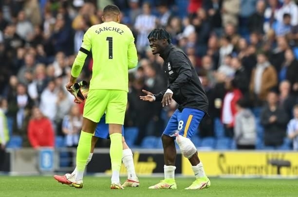 Brighton's Ivorian midfielder Yves Bissouma wears an ice pack on his leg as he speaks to Brighton's Spanish goalkeeper Robert Sanchez after the...
