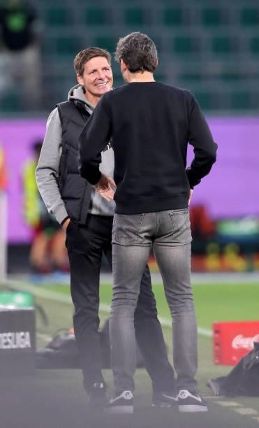 Frankfurt's Austrian head coach Oliver Glasner talks with Wolfsburg's Dutch head coach Mark van Bommel prior to the German first division Bundesliga...