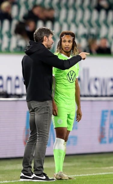 Wolfsburg's Dutch head coach Mark van Bommel talks with his player Wolfsburg's Swiss defender Kevin Mbabu during the German first division Bundesliga...