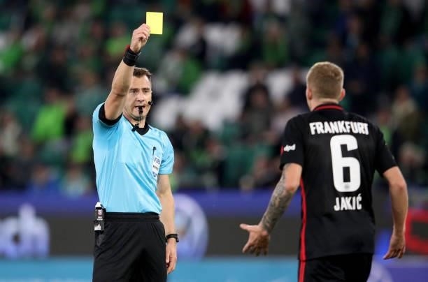 Referee Felix Zwayer shows the yellow card to Frankfurt's Croatian midfielder Kristijan Jakic during the German first division Bundesliga football...