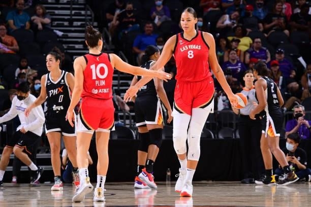 Liz Cambage hi-fives Kelsey Plum of the Las Vegas Aces during the game against the Phoenix Mercury on September 19, 2021 at Footprint Center in...